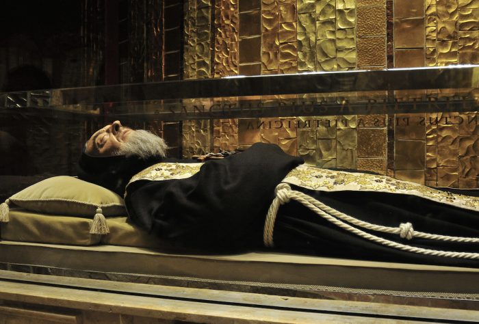 Padre Pio seems to be sleeping inside his glass case.